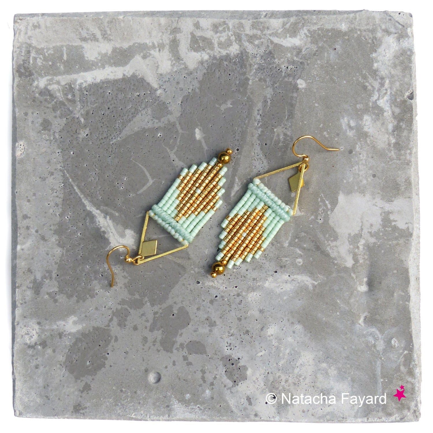 Peut inclure: Une paire de boucles d'oreilles géométriques dorées et vert clair avec un design triangulaire. Les boucles d'oreilles sont faites de petites perles et sont suspendues à des crochets dorés.