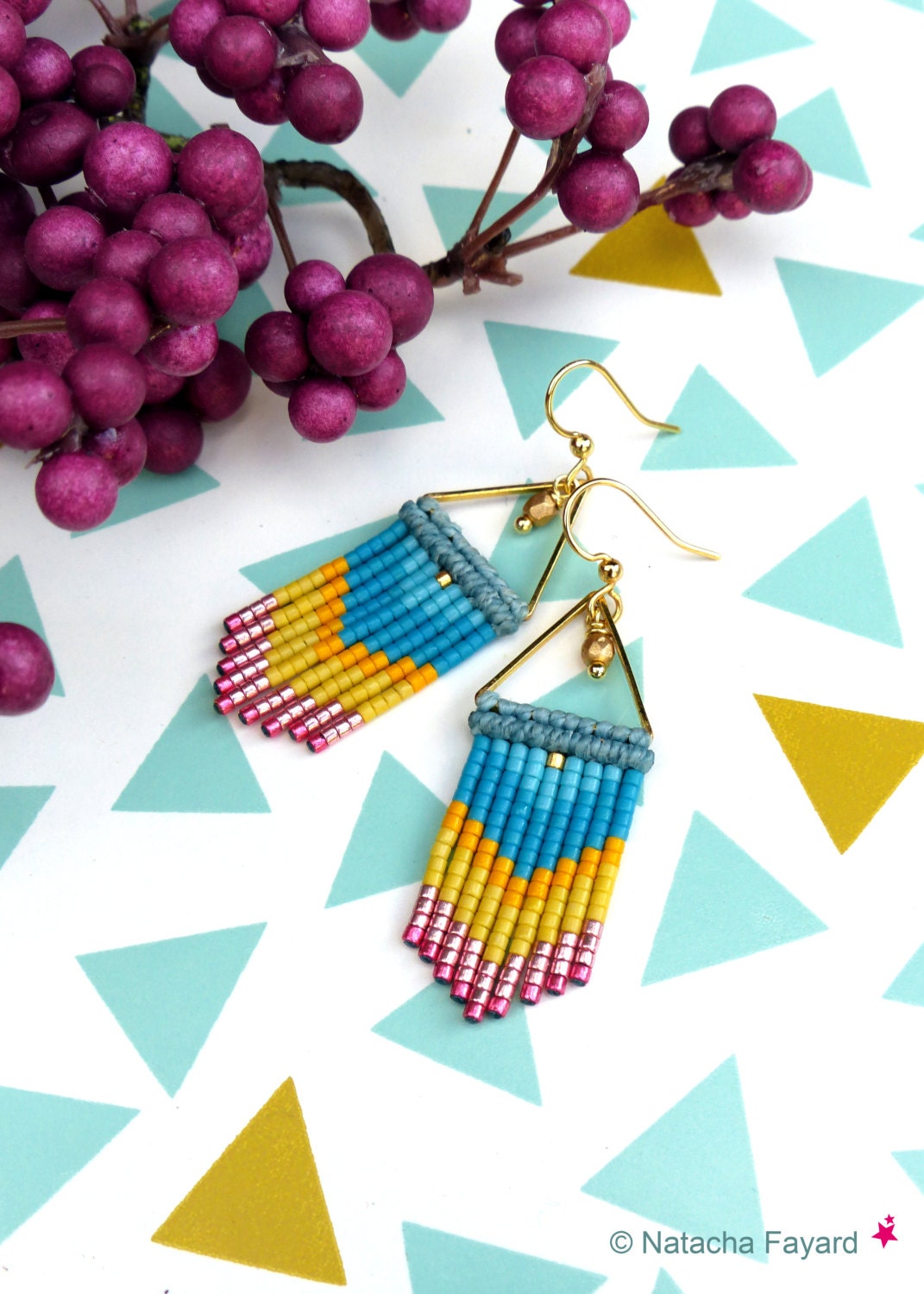 Peut inclure: Une paire de boucles d'oreilles triangulaires dorées avec une frange de perles turquoise, jaunes et roses.