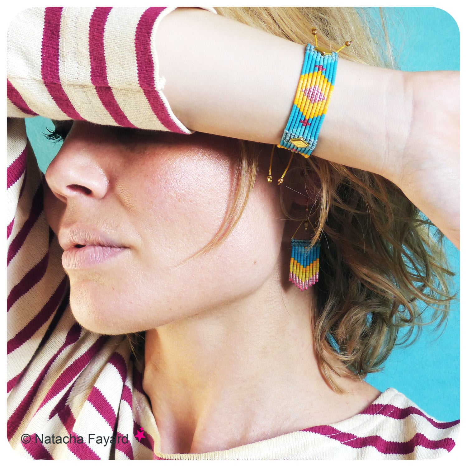 Peut inclure: Une femme portant une chemise rayée avec un bracelet en perles bleu, jaune et rose et des boucles d'oreilles assorties. Le bracelet et les boucles d'oreilles ont un motif géométrique.