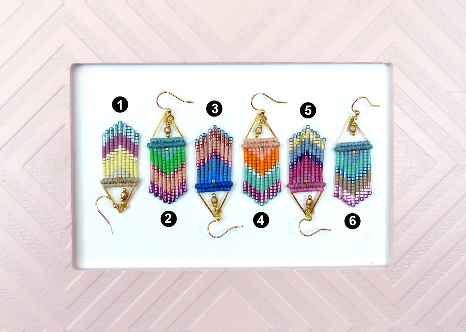Peut inclure: Six paires de boucles d'oreilles en perles colorées avec des motifs géométriques. Chaque paire est numérotée de 1 à 6.