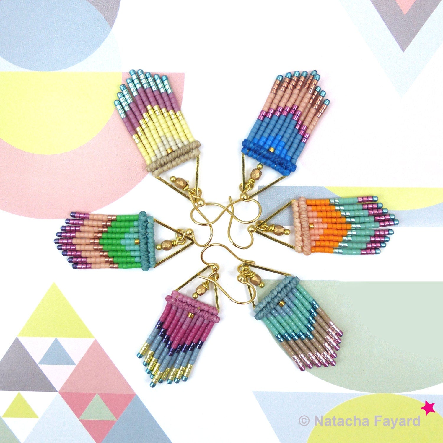 Peut inclure: Six paires de boucles d'oreilles à franges perlées colorées disposées en étoile. Chaque paire présente une palette de couleurs unique, dont le bleu, l'orange, le rose et le vert, avec des crochets d'oreilles dorés. Les boucles d'oreilles sont posées sur un fond blanc avec des formes géométriques.