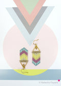 Peut inclure: Une paire de boucles d'oreilles géométriques dorées avec un motif en chevron composé de perles roses, jaunes et bleues. Les boucles d'oreilles sont suspendues à un triangle doré.