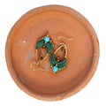Peut inclure: Une paire de boucles d'oreilles vertes et dorées avec des pierres turquoise. Les boucles d'oreilles sont en macramé et ont une forme de larme.