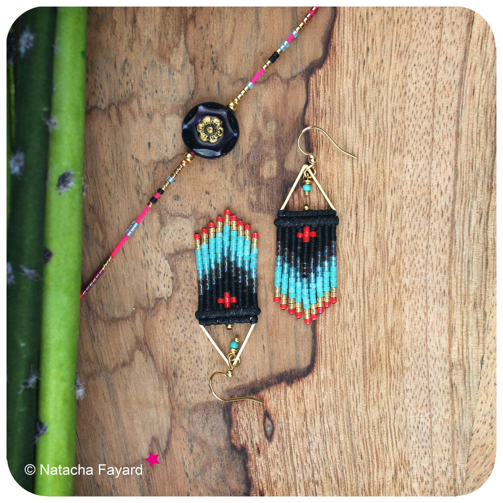 Peut inclure: Une paire de boucles d'oreilles pendantes avec des perles noires, turquoise et rouges. Les boucles d'oreilles sont en métal doré et ont un design géométrique.