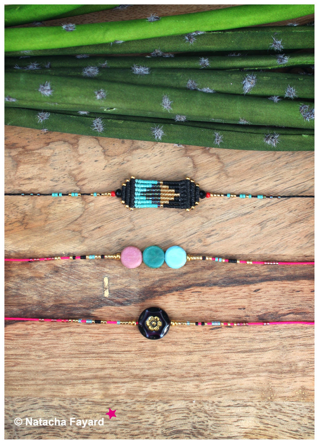 Peut inclure: Trois bracelets en perles avec des breloques différentes. Le bracelet du haut a un charme tissé noir et or. Le bracelet du milieu a trois perles rondes en rose, vert et bleu. Le bracelet du bas a un charme noir avec un motif de fleur dorée.