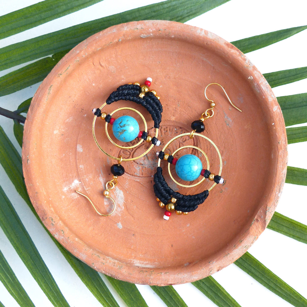 Peut inclure: Une paire de boucles d'oreilles pendantes avec des pierres turquoise, du fil noir et des accents dorés. Les boucles d'oreilles présentent un design circulaire avec un cercle plus petit à l'intérieur.