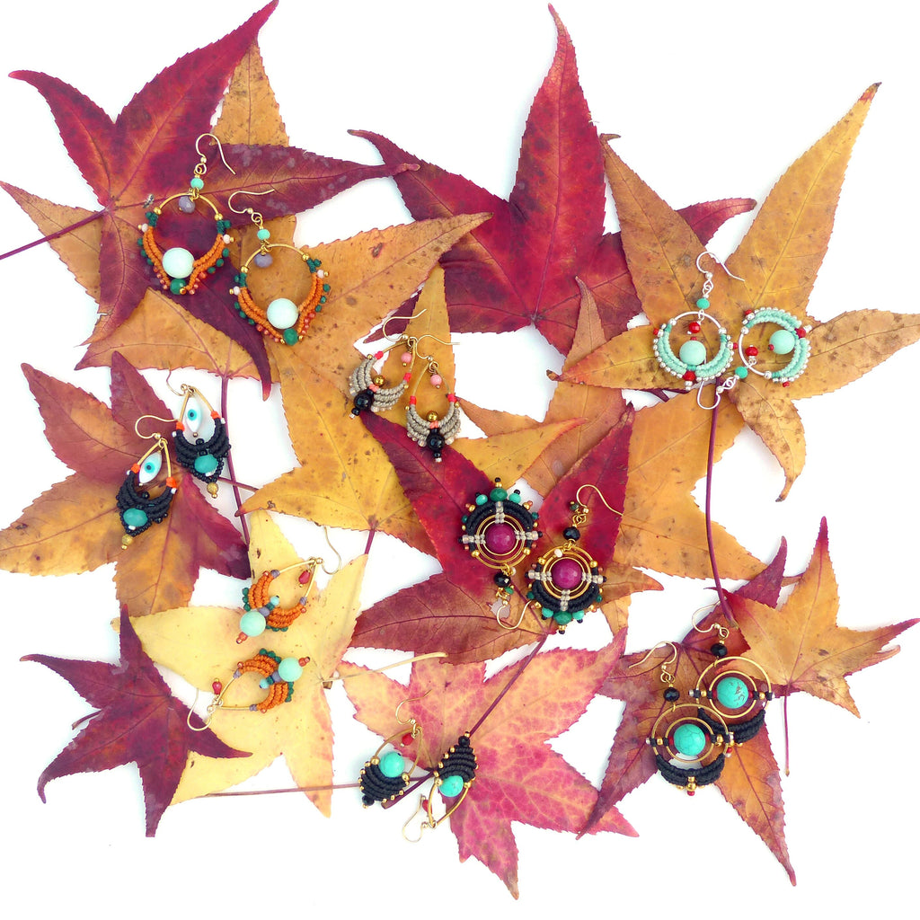 Peut inclure: Une collection de boucles d'oreilles en perles colorées avec différentes formes et motifs, disposées sur un lit de feuilles d'automne.