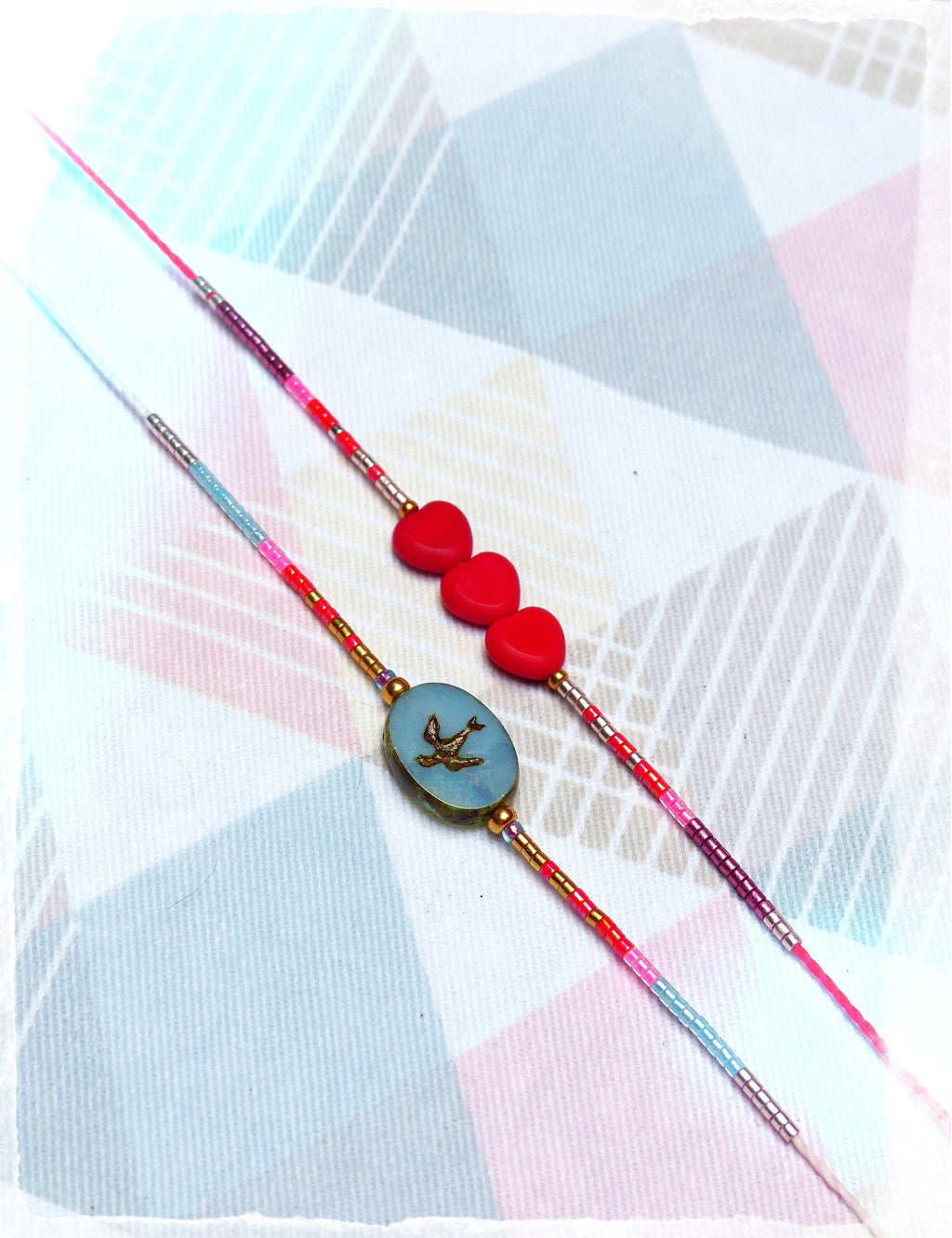 Peut inclure: Deux bracelets d'amitié avec des perles colorées, l'un avec des breloques en forme de cœur rouge et l'autre avec un charme ovale bleu orné d'un oiseau doré.