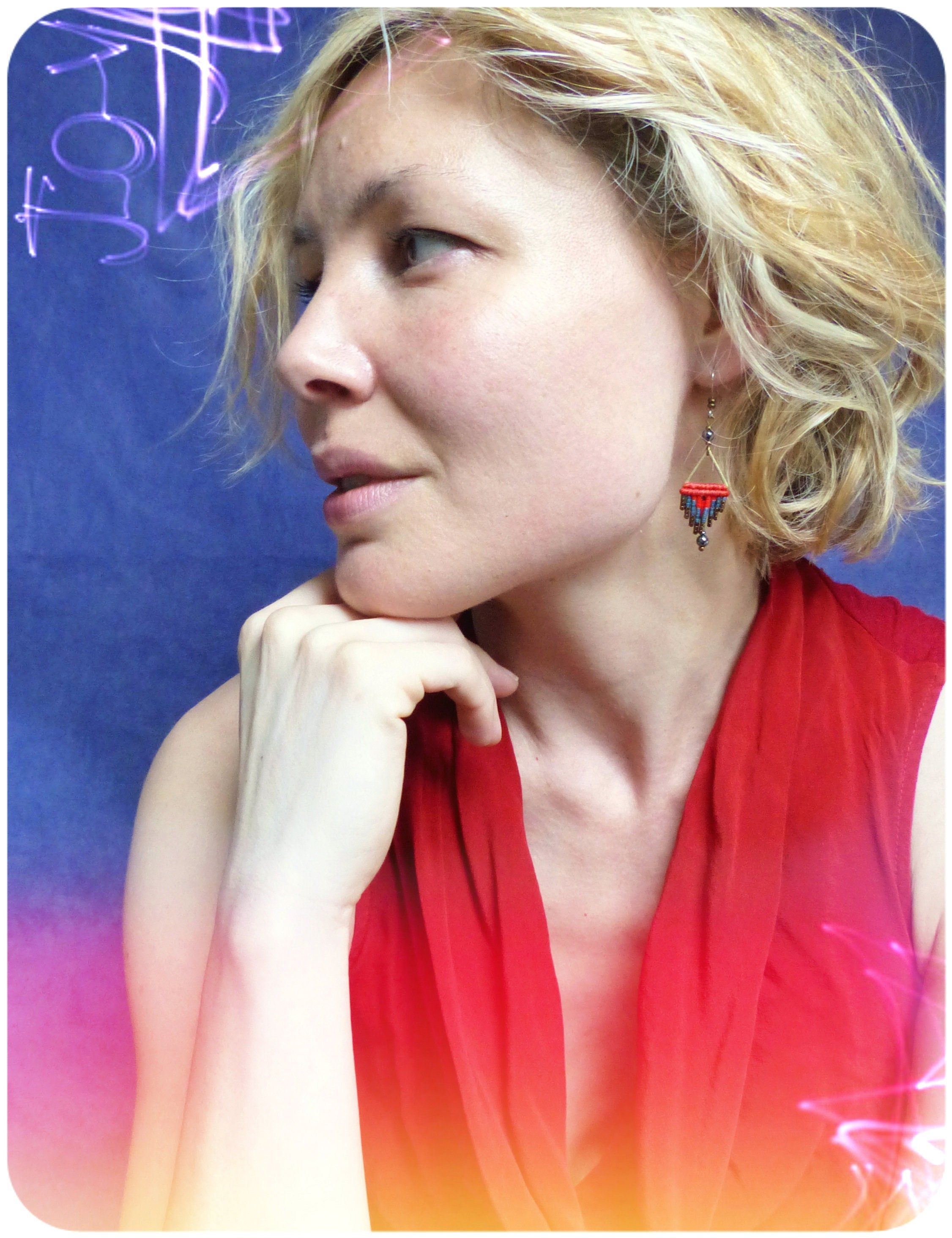 Peut inclure: Une femme aux cheveux blonds portant un haut rouge et des boucles d'oreilles en perles. Les boucles d'oreilles sont bleues, rouges et dorées.