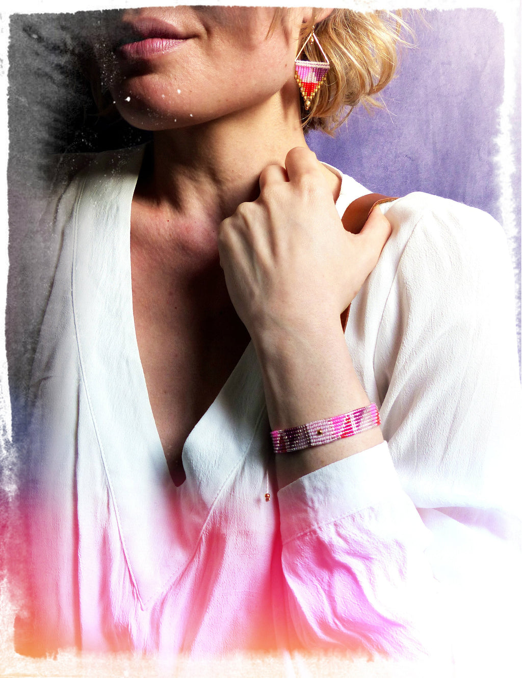 Peut inclure: Une femme portant une chemise blanche avec un bracelet en perles rose et blanc au poignet. Elle porte également des boucles d'oreilles triangulaires roses et dorées.
