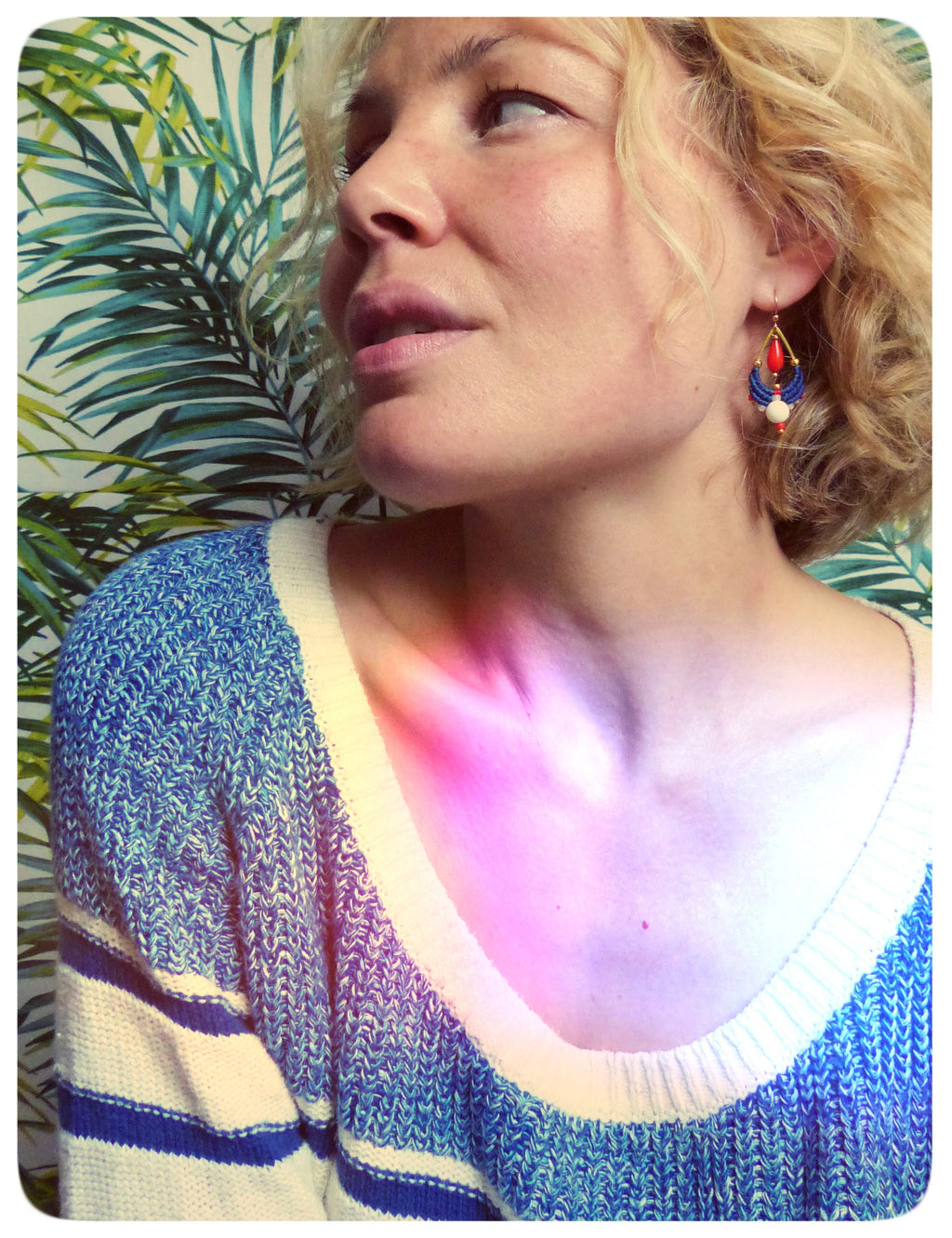 Peut inclure: Une femme portant un pull rayé bleu et blanc avec une paire de boucles d'oreilles pendantes. Les boucles d'oreilles sont faites de perles bleues, rouges et blanches et ont une base dorée.