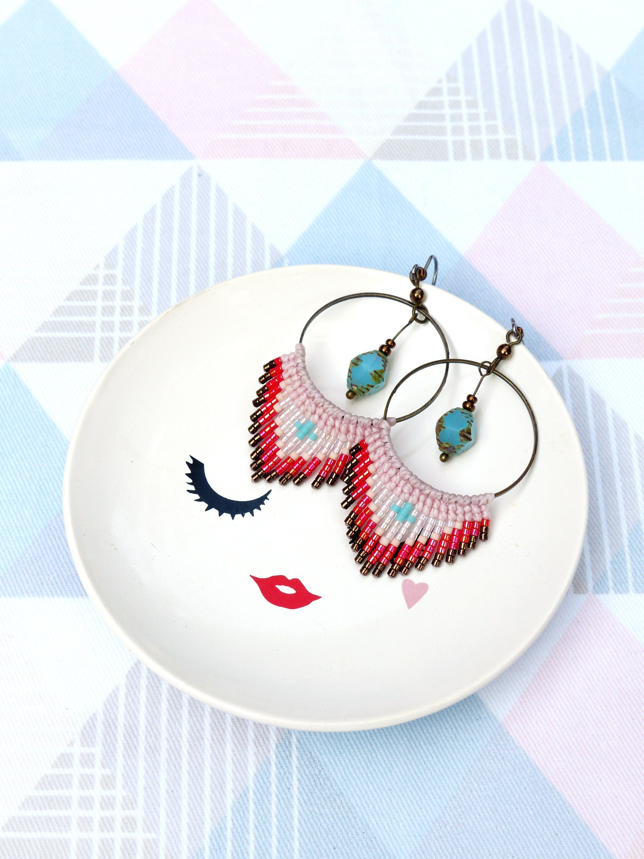 Peut inclure: Une paire de boucles d'oreilles créoles avec une frange de perles roses, rouges et blanches. Les boucles d'oreilles ont une perle turquoise au bas de chaque créole.