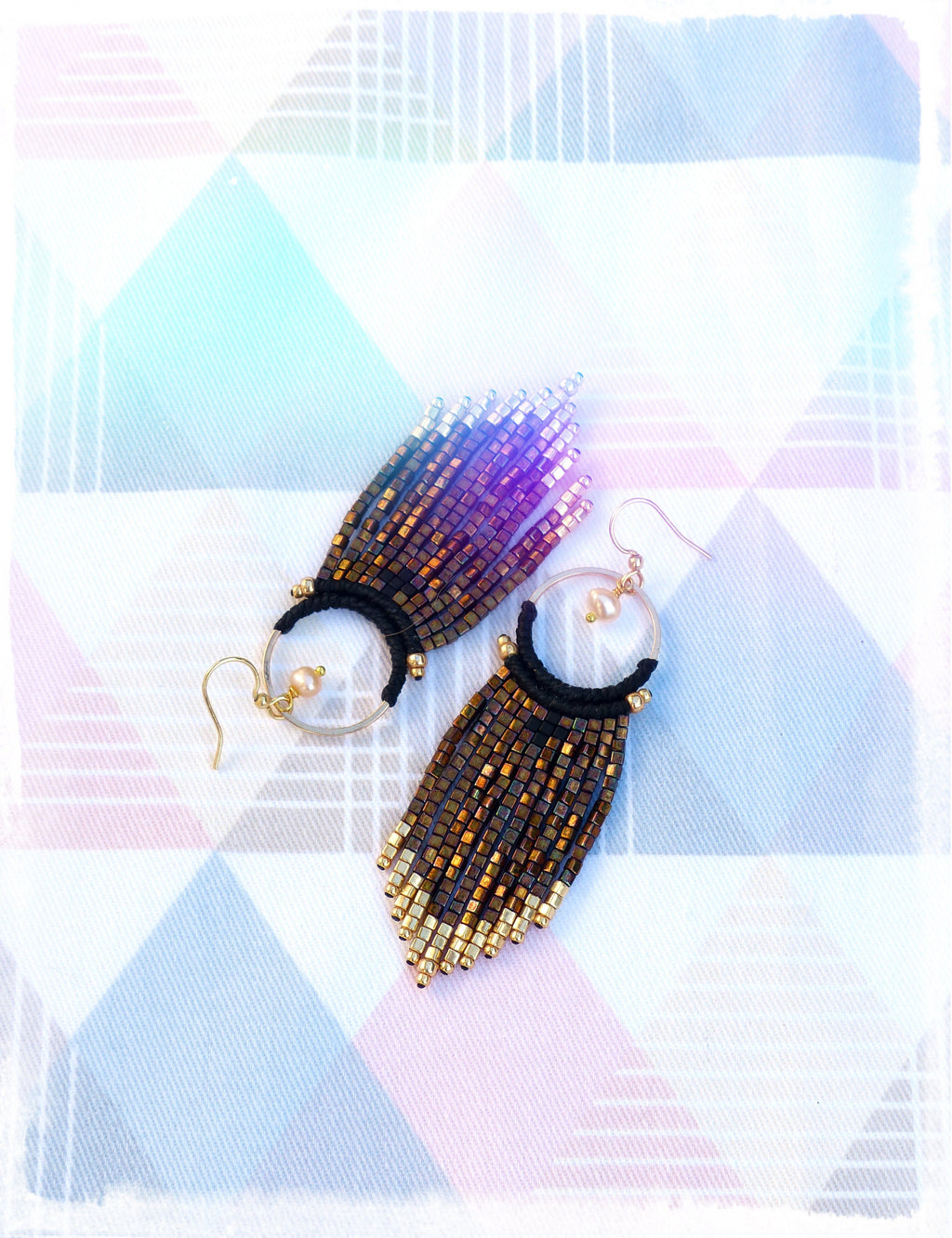 Peut inclure: Une paire de boucles d'oreilles en perles dorées et brunes avec un pompon noir. Les boucles d'oreilles ont un design de cerceau avec un petit accent de perle.