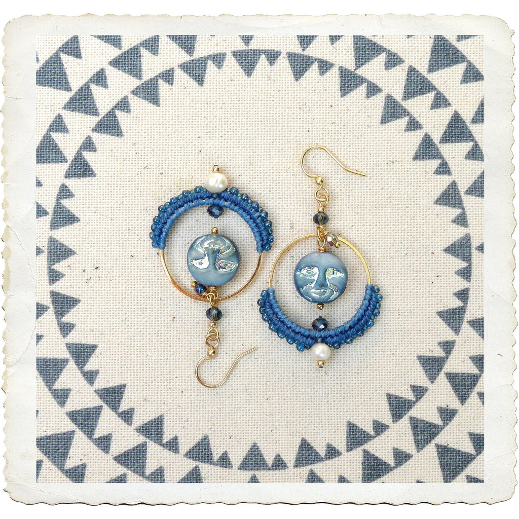 Peut inclure: Une paire de boucles d'oreilles bleues et dorées avec un charme en verre facetté et un accent de perle. Les boucles d'oreilles sont faites de macramé et ont un style bohème.