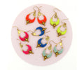 Peut inclure: Six paires de boucles d'oreilles en perles colorées avec des accents dorés. Les boucles d'oreilles sont présentées sur un fond rose.
