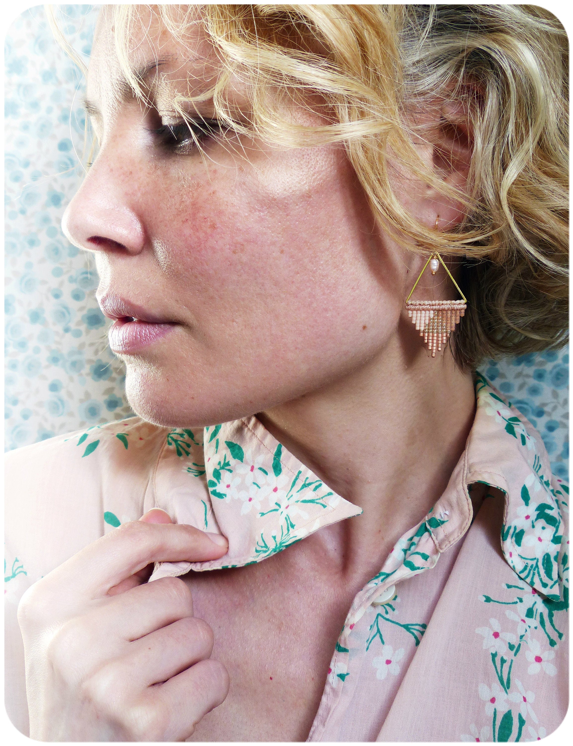 Peut inclure: Une femme portant une chemise à fleurs rose avec une boucle d'oreille triangulaire en perles dorées et roses.