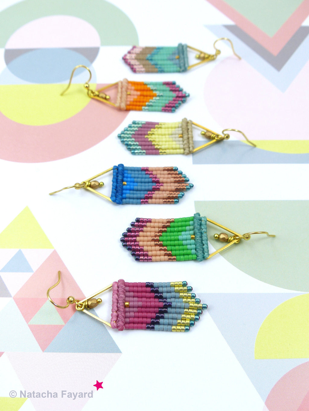 Peut inclure: Cinq paires de boucles d'oreilles en perles colorées avec des motifs géométriques. Chaque boucle d'oreille présente une monture métallique en forme de triangle et une frange de perles colorées.