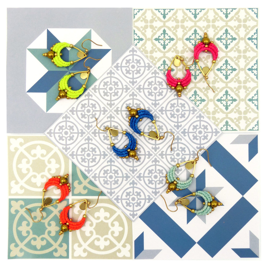 Peut inclure: Assortiment de boucles d'oreilles pendantes faites à la main avec des motifs de perles colorées. Les boucles d'oreilles présentent une variété de couleurs, notamment le bleu, le vert, le rose et le jaune. Les boucles d'oreilles sont présentées sur un fond de carreaux.