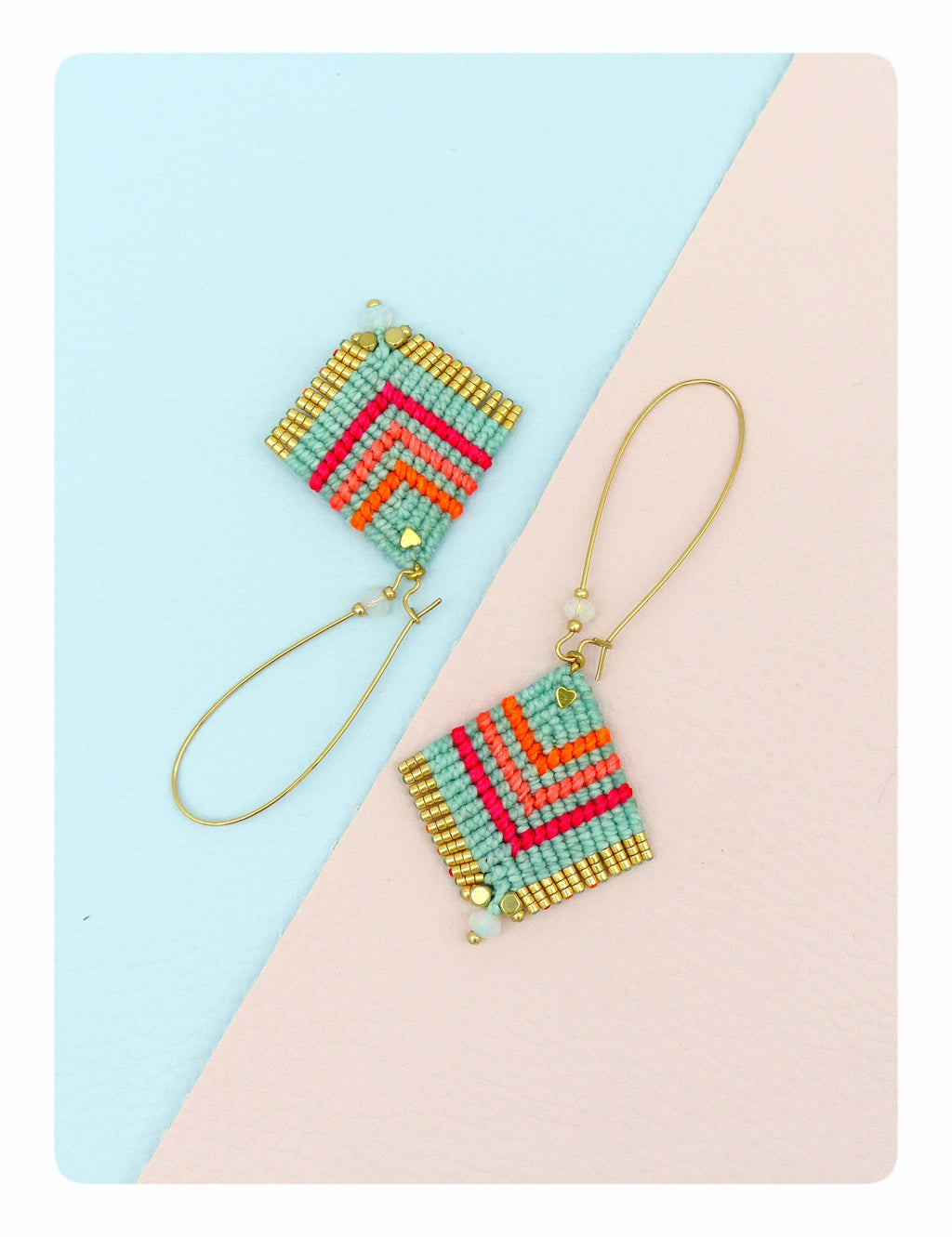 Peut inclure: Une paire de boucles d'oreilles en perles turquoise et dorées avec un motif géométrique. Les boucles d'oreilles sont sur un fond bleu clair et rose.