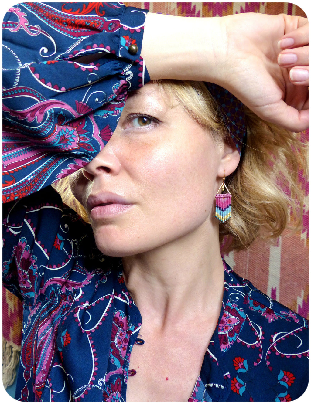 Peut inclure: Une femme portant un chemisier à motif paisley bleu et rose avec une boucle d'oreille à franges de perles. 