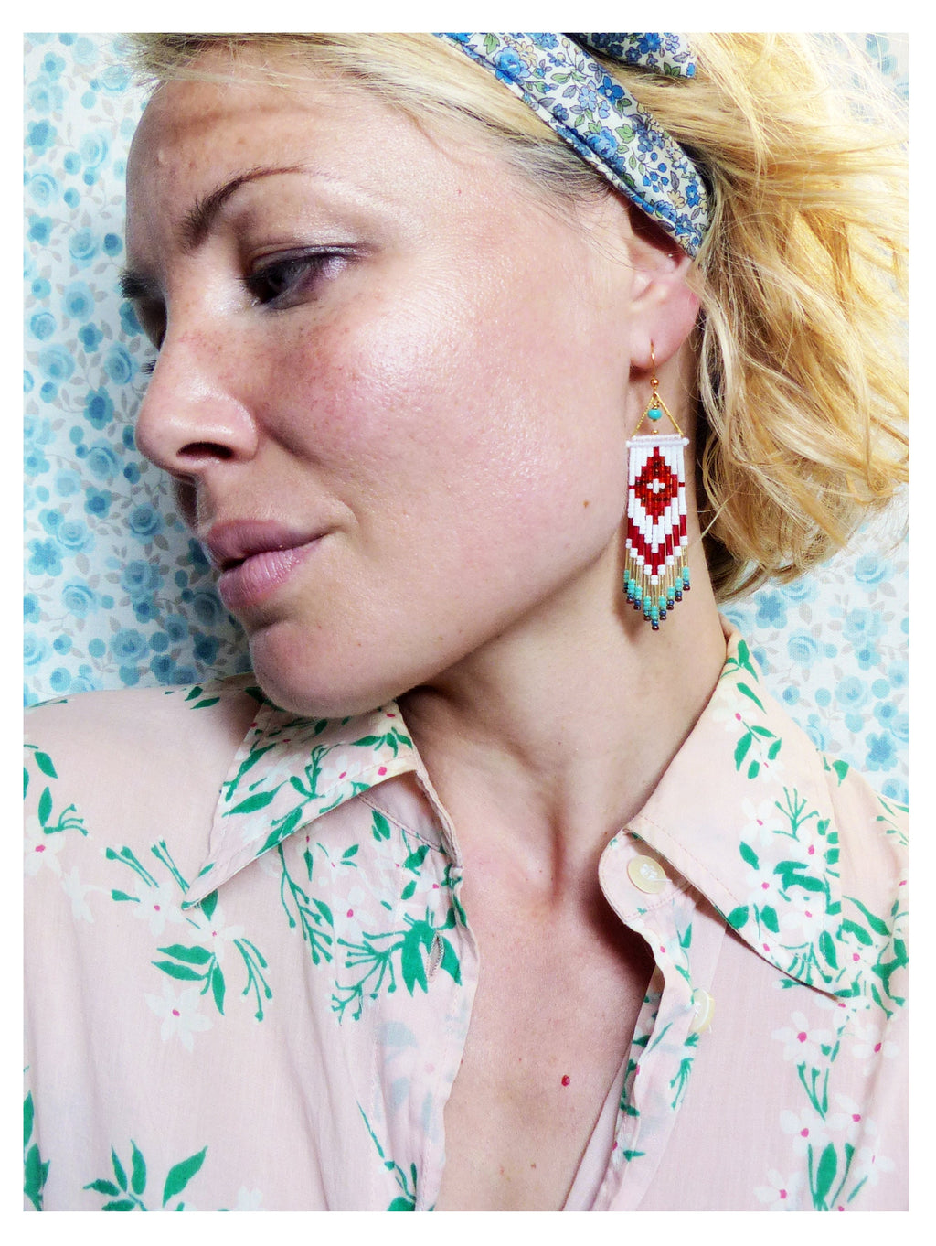 Peut inclure: Une femme portant un bandeau floral et une chemise rose à fleurs avec une boucle d'oreille à franges de perles blanches et rouges.