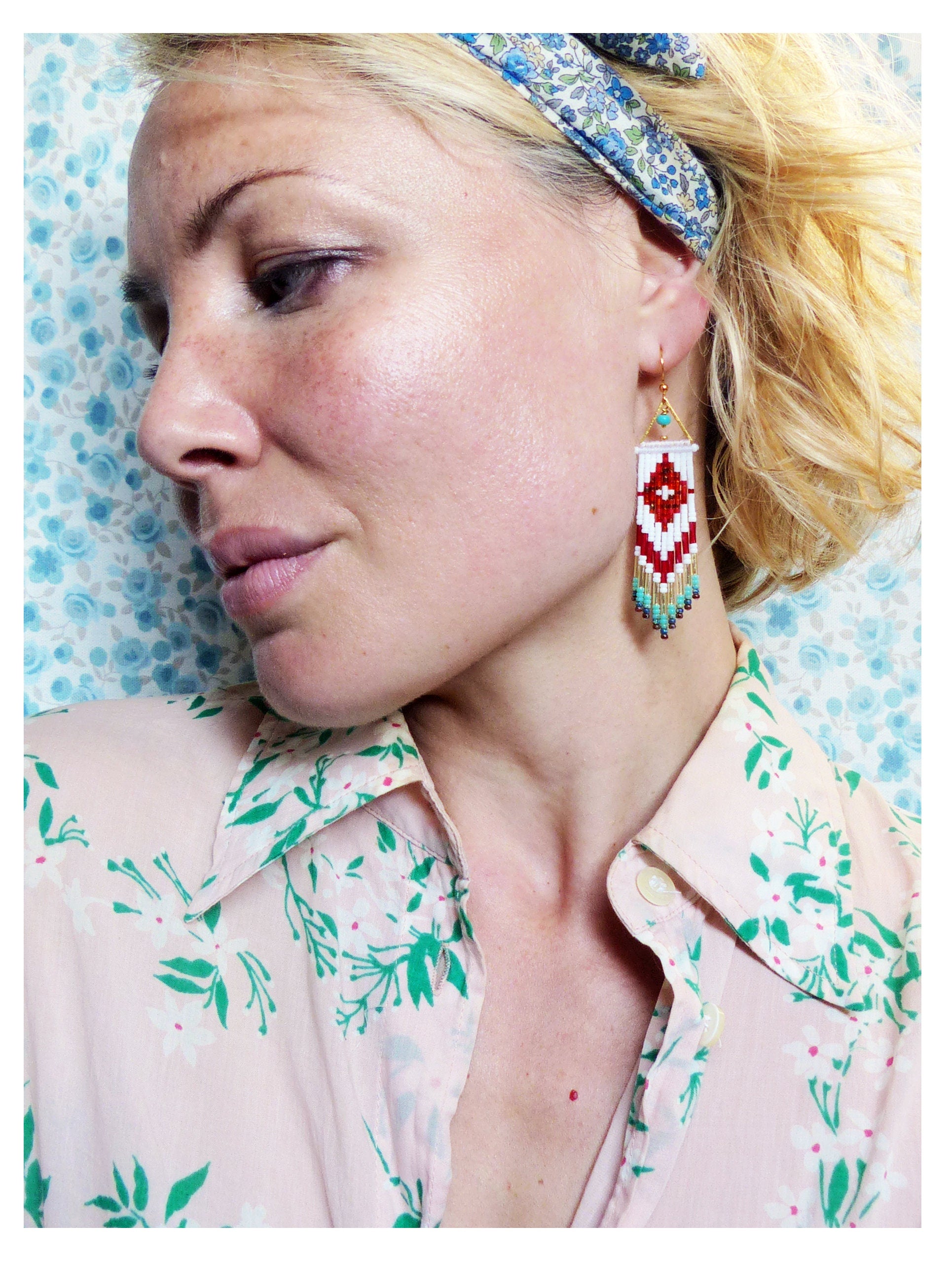Peut inclure: Une femme portant un bandeau floral et une chemise rose à fleurs avec une boucle d'oreille à franges de perles blanches et rouges.