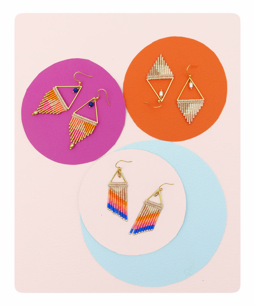 Peut inclure: Trois paires de boucles d'oreilles faites à la main avec des montures en métal doré et des franges de perles colorées. Les boucles d'oreilles sont présentées sur des cercles roses, oranges et bleus sur un fond rose clair. Les franges de perles présentent des nuances d'orange, de rose, de bleu et d'or.