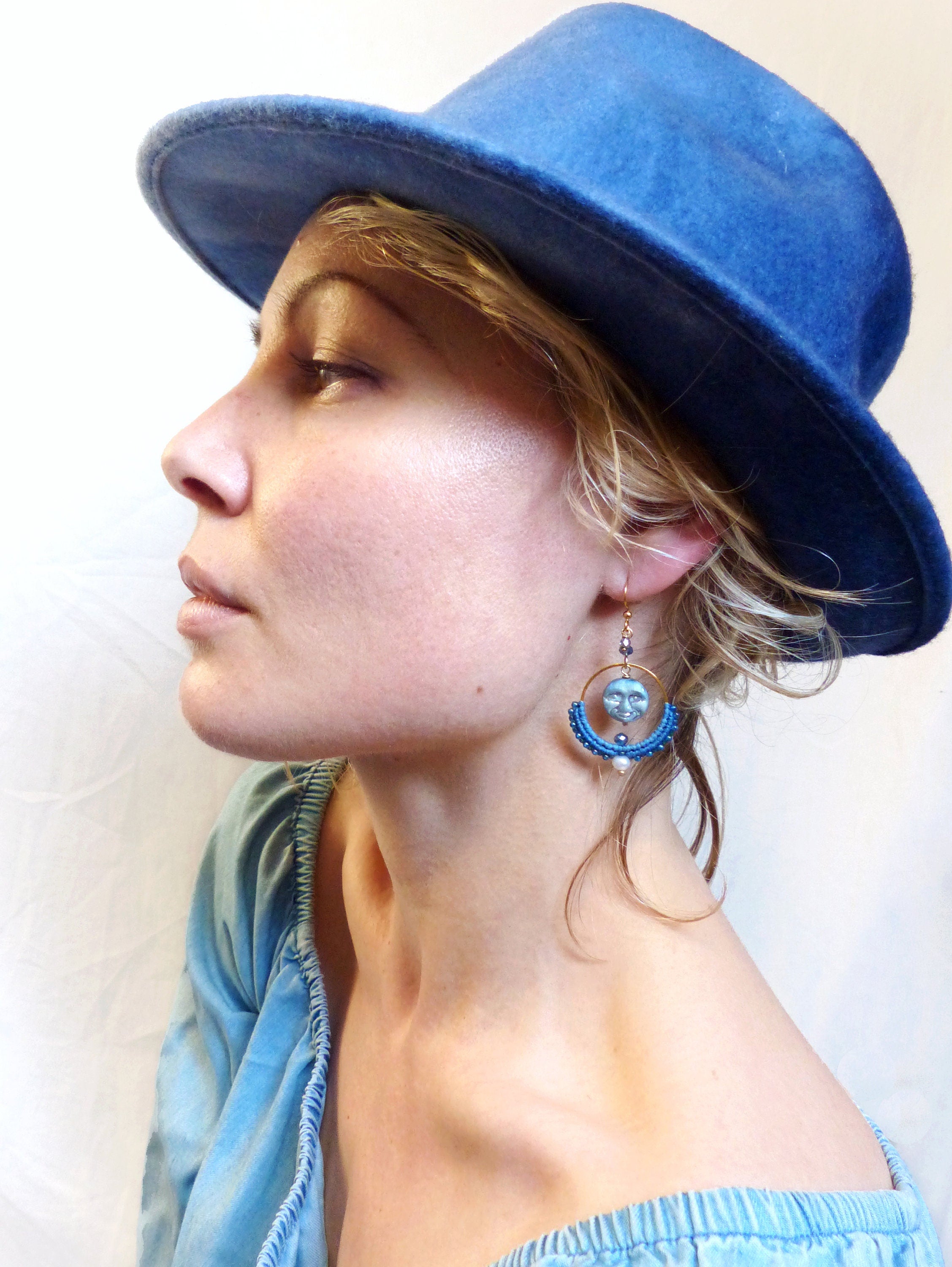 Peut inclure: Une femme portant un chapeau en jean bleu et un haut en jean bleu avec une paire de boucles d'oreilles bleues et dorées représentant un motif de lune et d'étoile.