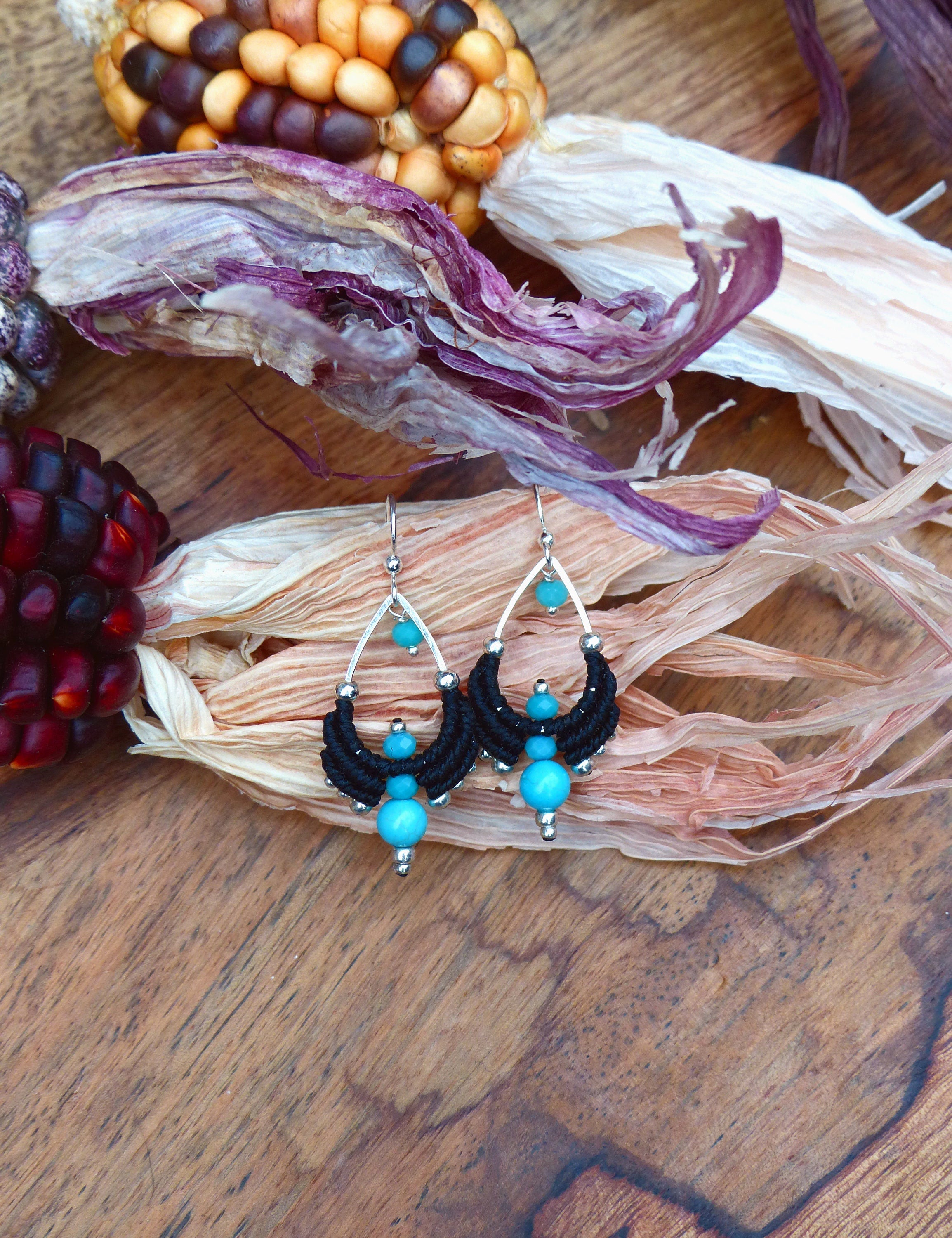 Peut inclure: Une paire de boucles d'oreilles pendantes en macramé noir et perles turquoise. Les boucles d'oreilles sont en argent et ont une forme de larme.