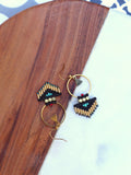 Peut inclure: Une paire de boucles d'oreilles créoles dorées avec des franges de perles noires et dorées. Les franges comportent des perles turquoise et rouges.