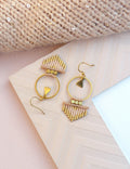 Peut inclure: Une paire de boucles d'oreilles créoles dorées avec une frange de perles roses et dorées. Les boucles d'oreilles ont un charme triangulaire suspendu à la créole.