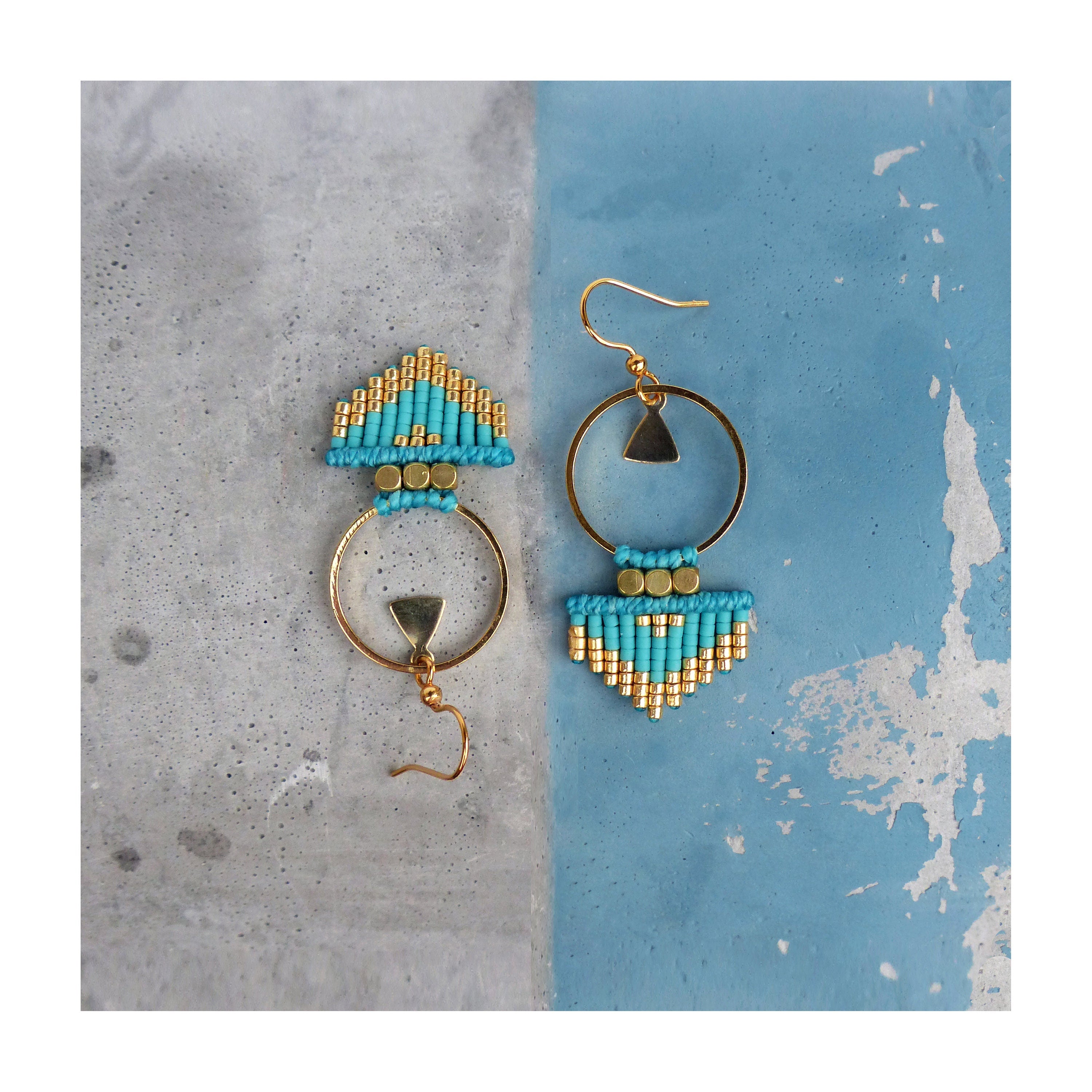 Peut inclure: Une paire de boucles d'oreilles créoles dorées avec des franges de perles turquoise et dorées et un petit charme triangulaire.
