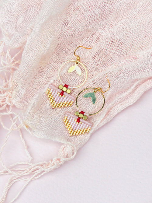 Peut inclure: Une paire de boucles d'oreilles en or avec des formes de goutte en perles roses et rouges et des cercles en or avec des accents de feuilles.