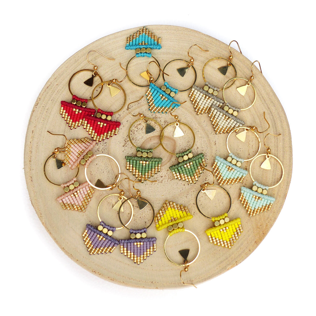 Peut inclure: Un ensemble de 10 paires de boucles d'oreilles en perles avec des cercles dorés et des franges. Les boucles d'oreilles sont de différentes couleurs, notamment rouge, bleu, vert, jaune et violet.