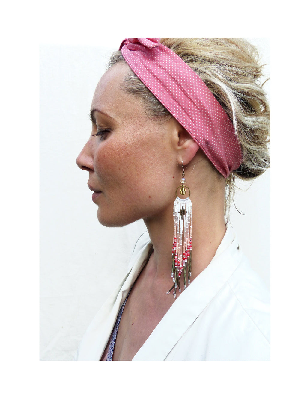 Peut inclure: Une paire de longues boucles d'oreilles en perles avec un motif blanc, rose et or. Les boucles d'oreilles présentent un petit pendentif circulaire en haut et pendent jusqu'à la poitrine.