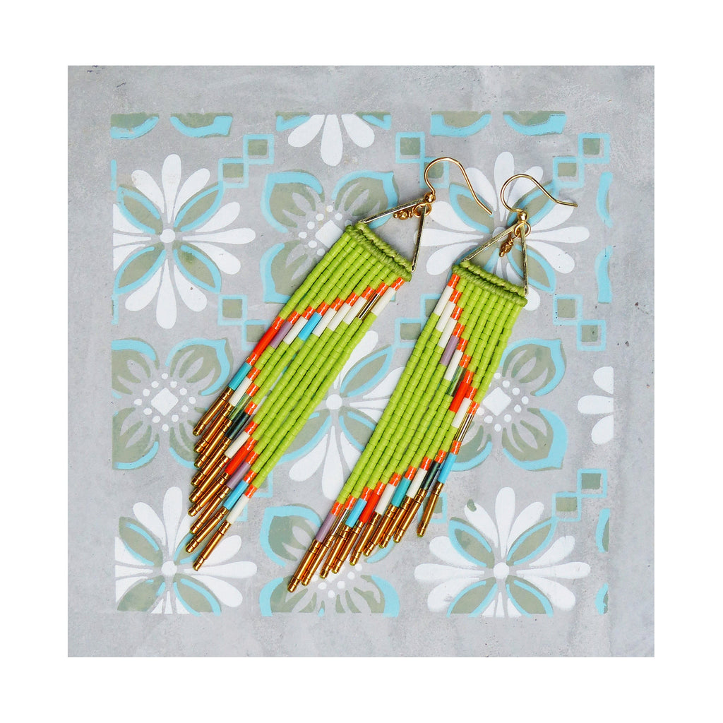 Peut inclure: Une paire de longues boucles d'oreilles en perles vertes avec des accents dorés. Les boucles d'oreilles sont faites avec une variété de perles colorées, y compris orange, blanc et bleu.