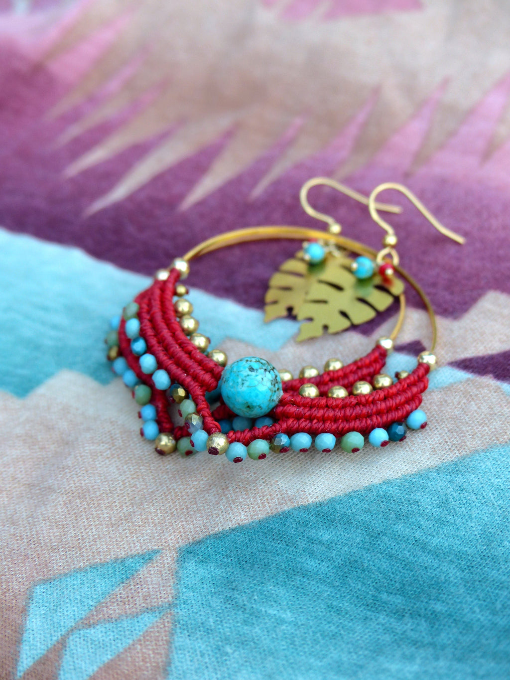 Peut inclure: Boucles d'oreilles créoles en perles rouges et turquoise avec un pendentif en feuille d'or. Les boucles d'oreilles sont faites à la main et présentent un design unique.