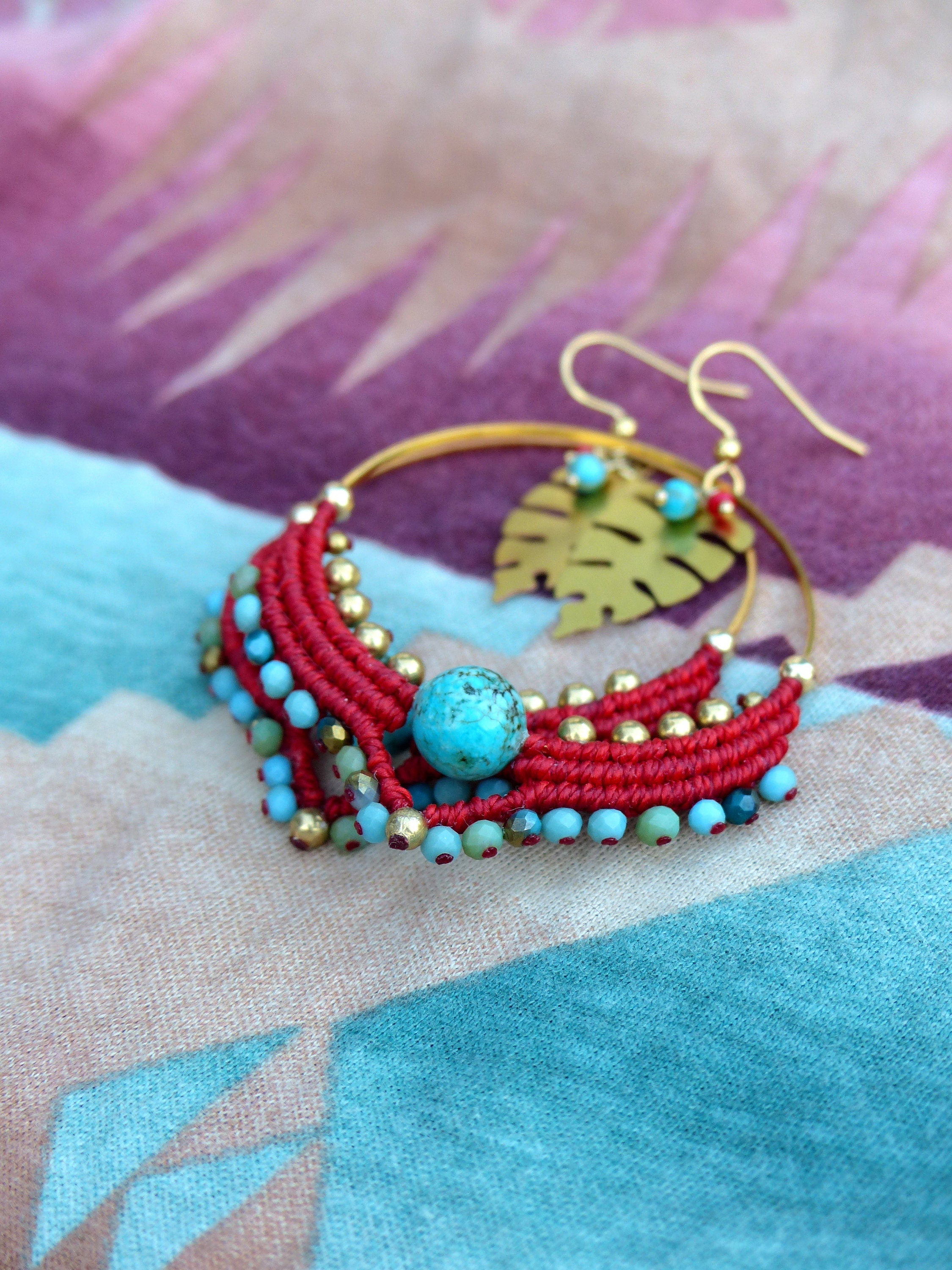 Peut inclure: Boucles d'oreilles créoles en perles rouges et turquoise avec un pendentif en feuille d'or. Les boucles d'oreilles sont faites à la main et présentent un design unique.