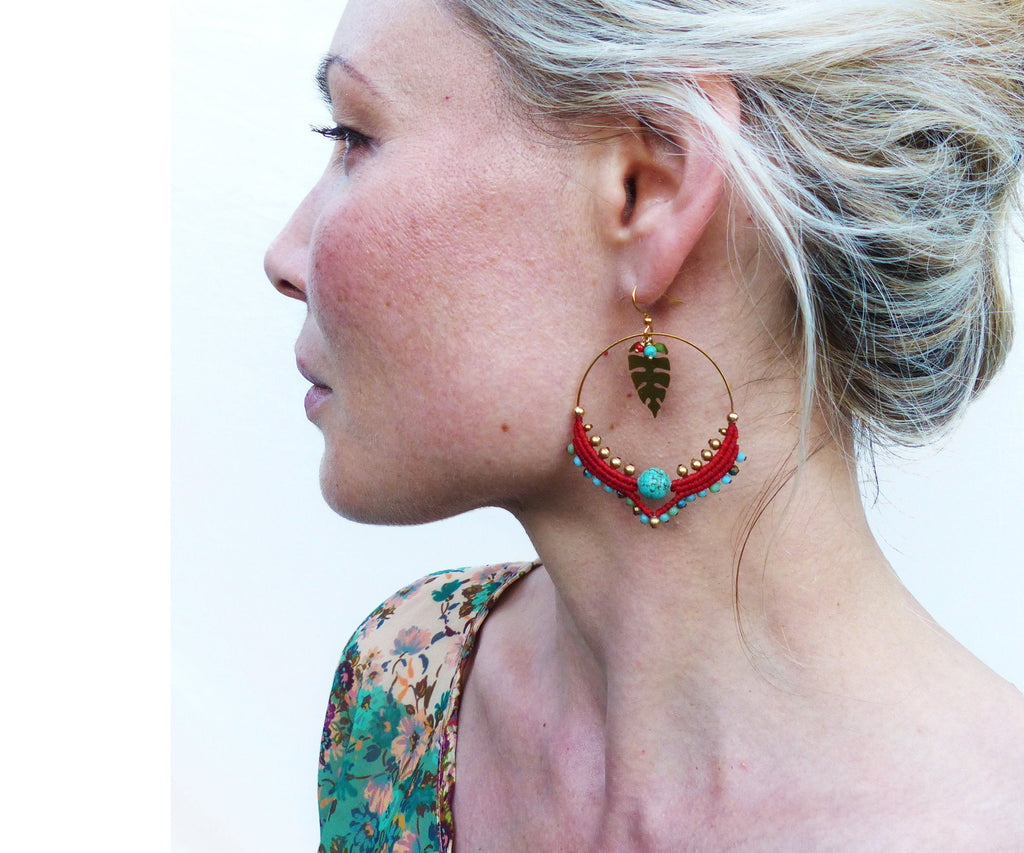 Peut inclure: Boucles d'oreilles créoles dorées avec des perles rouges et turquoise et un pendentif en forme de feuille dorée.