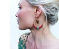 Peut inclure: Boucles d'oreilles créoles dorées avec des perles rouges et turquoise et un pendentif en forme de feuille dorée.
