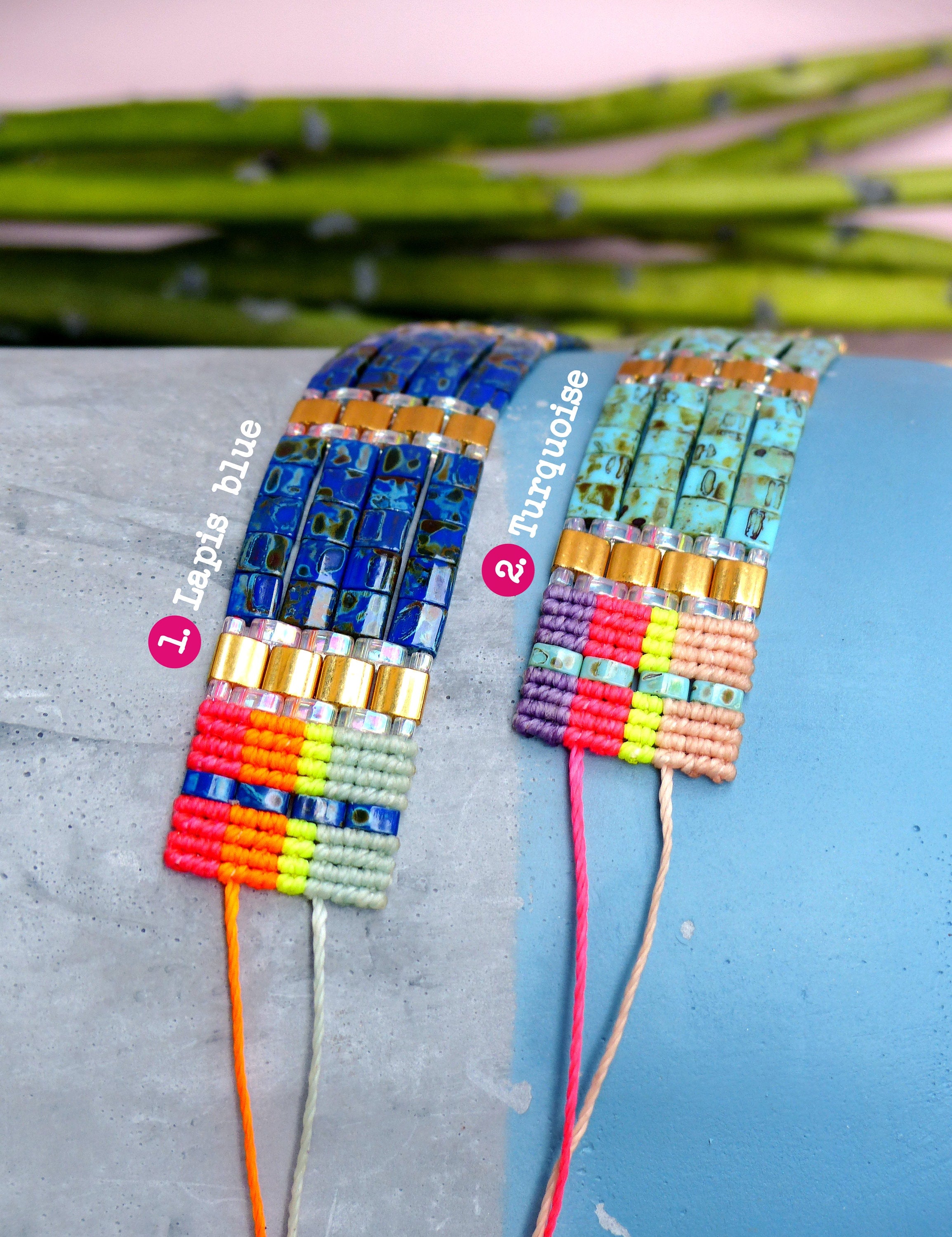 Peut inclure: Deux bracelets d'amitié colorés avec des fils tissés et des perles. Le bracelet de gauche est bleu avec des perles dorées et le texte "1. Lapis blue". Le bracelet de droite est turquoise avec des perles dorées et le texte "2. Turquoise".