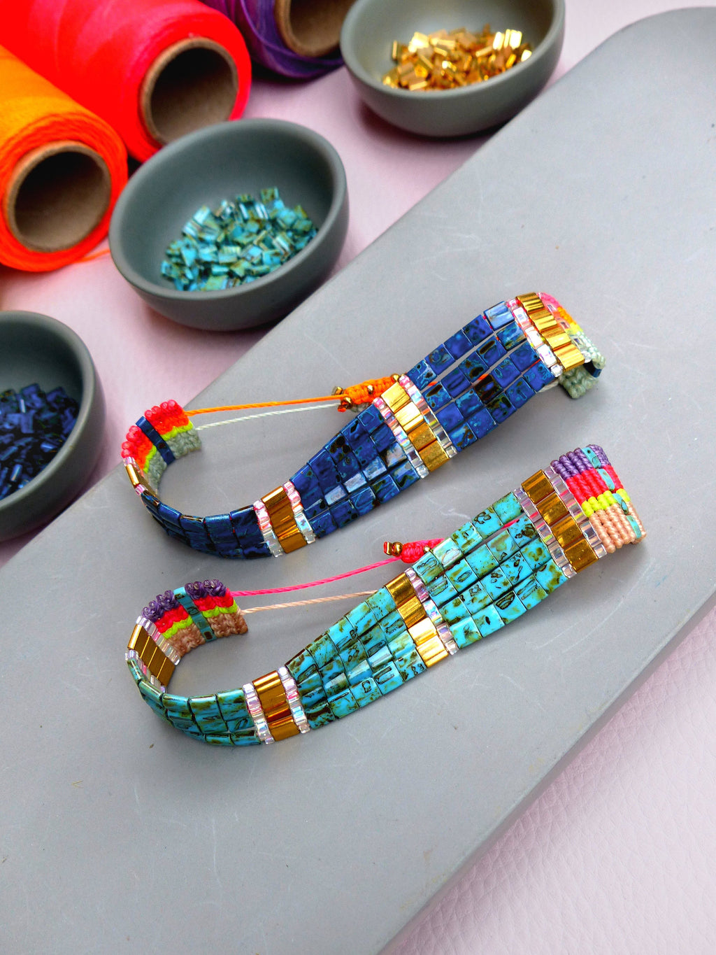 Peut inclure: Deux bracelets en perles avec un motif de fil multicolore. Un bracelet est bleu et turquoise, l'autre est bleu et sarcelle.