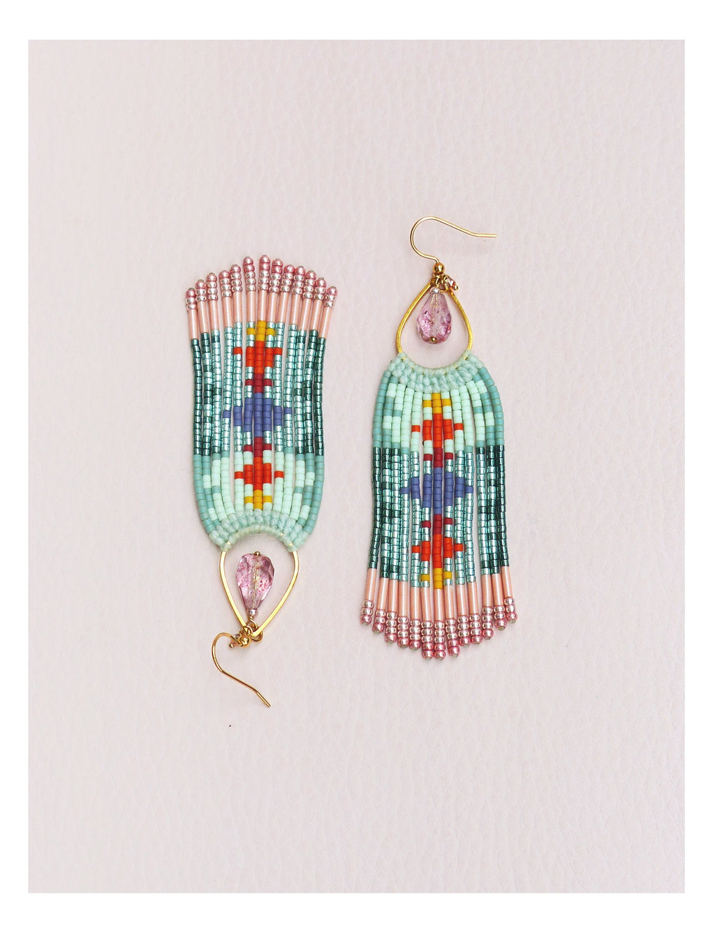 Peut inclure: Une paire de boucles d'oreilles perlées avec un motif géométrique. Les boucles d'oreilles présentent une combinaison de perles bleu clair, roses, rouges et violettes. Chaque boucle d'oreille a un crochet doré et une gemme rose en forme de goutte.