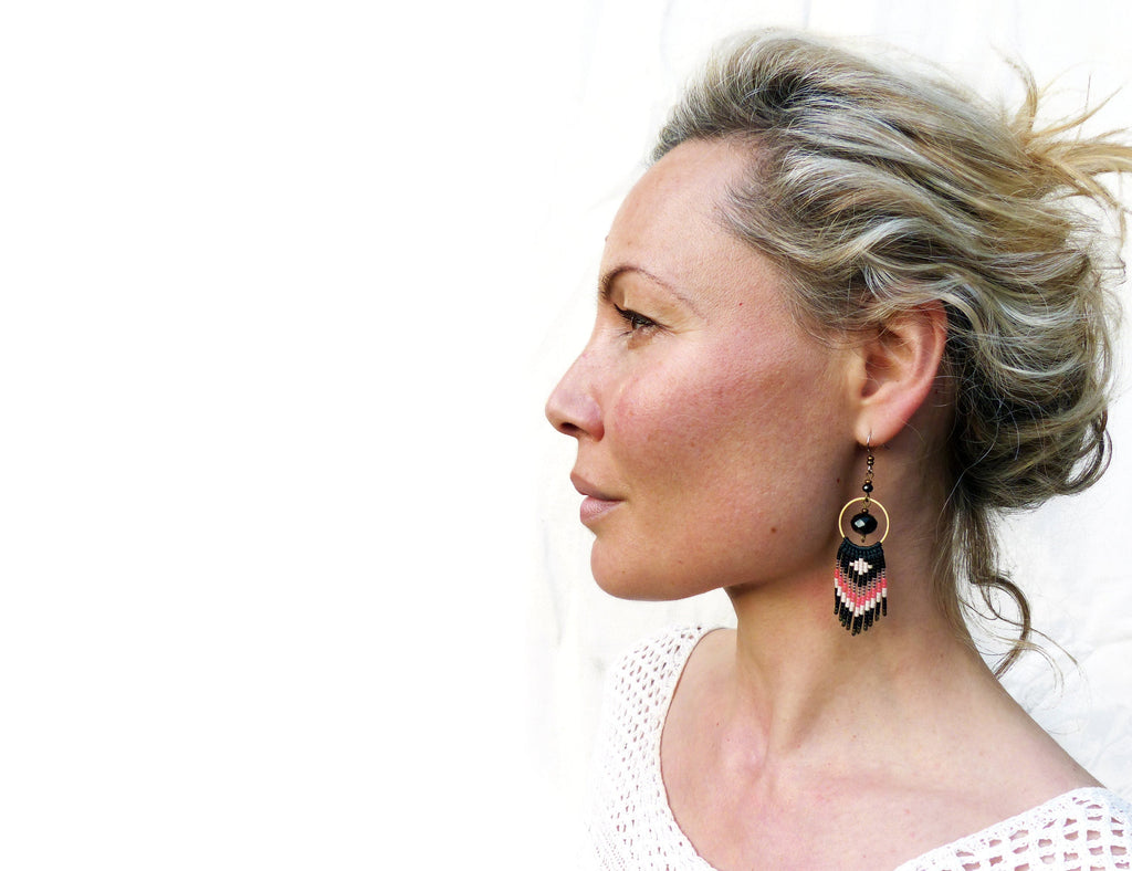 Peut inclure: Une femme aux cheveux blonds portant une paire de boucles d'oreilles en perles noires et corail avec un accent de perle noire et un cercle doré.
