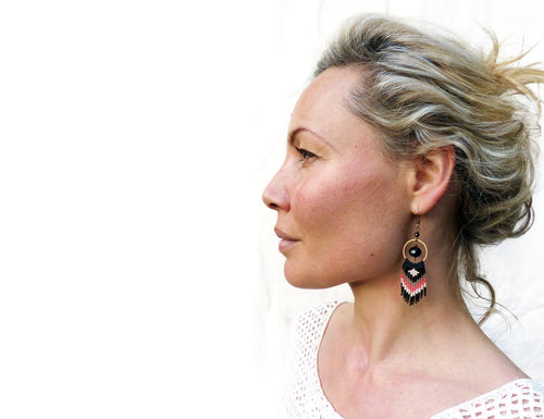 Peut inclure: Une femme aux cheveux blonds portant une paire de boucles d'oreilles en perles noires et corail avec un accent de perle noire et un cercle doré.