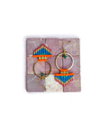 Peut inclure: Une paire de boucles d'oreilles créoles dorées avec des franges de perles colorées. Les franges sont composées de petites perles colorées dans des tons d'orange, de bleu et de rose. Les créoles sont simples et élégantes, et les franges ajoutent une touche de fantaisie.