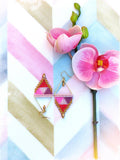 Peut inclure: Une paire de boucles d'oreilles géométriques en perles roses, rouges et dorées de forme triangulaire. Les boucles d'oreilles sont suspendues à des crochets dorés.