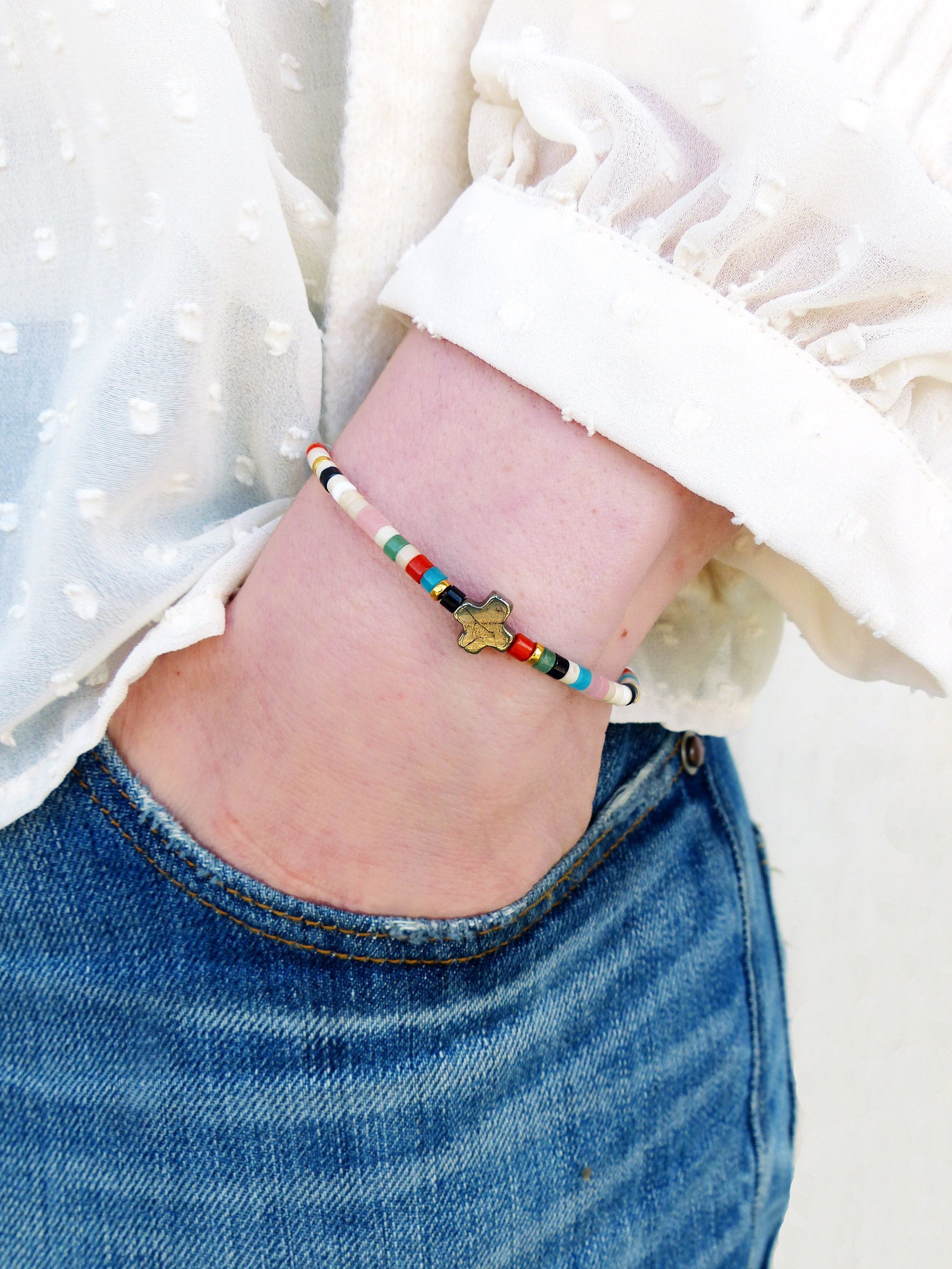Peut inclure: Un bracelet en perles colorées avec un charme en forme d'étoile. Le bracelet est composé de petites perles rondes de différentes couleurs, notamment rose, bleu, vert et blanc. Le charme en forme d'étoile est de couleur or et se trouve au centre du bracelet.