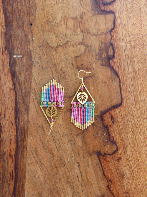 Peut inclure: Une paire de boucles d'oreilles en or avec des perles roses, bleues et vertes. Les boucles d'oreilles sont en forme de triangle et ont un motif de feuille au centre.