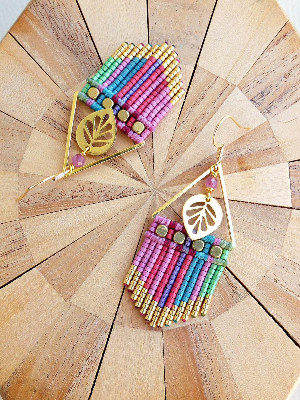 Peut inclure: Une paire de boucles d'oreilles en or avec une frange de perles rose, verte et bleue et un charme en feuille d'or. 